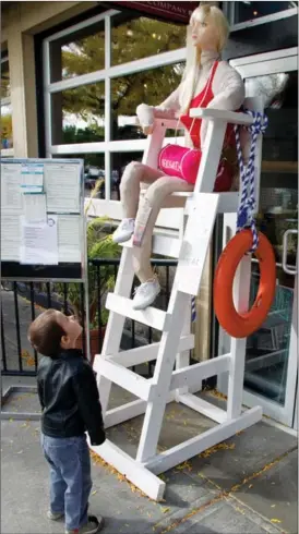  ??  ?? Nixen Paterson, 3, looks way up at the Peachland lifeguard scarecrow outside the Beach Cafe.