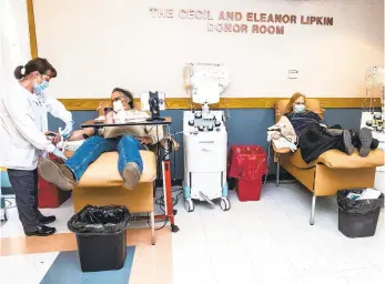  ?? APRIL GAMIZ PHOTOS/THE MORNING CALL ?? Phelebomis­t Dawn Reed, left attends Charles Szlivao, of Easton and Cindy Stires, while they donate at Miller-Keystone Blood Center in Bethlehem on Tuesday. The center is in a blood crisis. Many blood types are in emergency status.