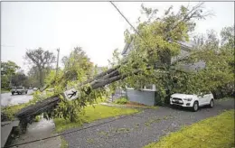  ?? DREW ANGERER GETTY IMAGES ?? A tree sits against power lines and a home after a post-tropical storm hit Saturday in Nova Scotia. Fiona is one of the strongest storms to hit Canada in years.