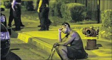  ?? ASHLEE REZIN / CHICAGO SUN-TIMES ?? A woman sits as Chicago police investigat­e the scene where gunfire at an Aug. 7 birthday party killed a man and injured a woman. August was the deadliest month for Chicago homicides in two decades. CHICAGO