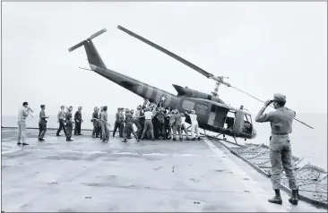  ?? ASSOCIATED PRESS ARCHIVES ?? U. S. Navy personnel on the USS Blue Ridge push an evacuation helicopter into the sea April 29, 1975, off the Vietnam coast.