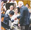  ??  ?? Kevin Chen shakes hands with Mark Russell Smith after winning the prestigiou­s e-piano Junior Competitio­n.