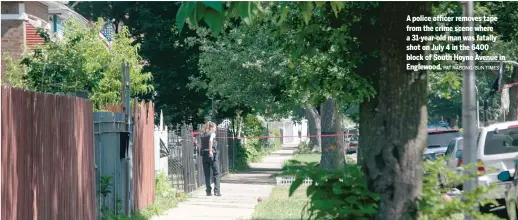  ?? PAT NABONG/ SUN- TIMES ?? A police officer removes tape from the crime scene where a 31- year- old man was fatally shot on July 4 in the 6400 block of South Hoyne Avenue in Englewood.