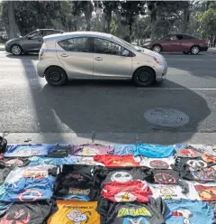  ?? AP ?? T-shirts for sale are laid on a pavement in Los Angeles.