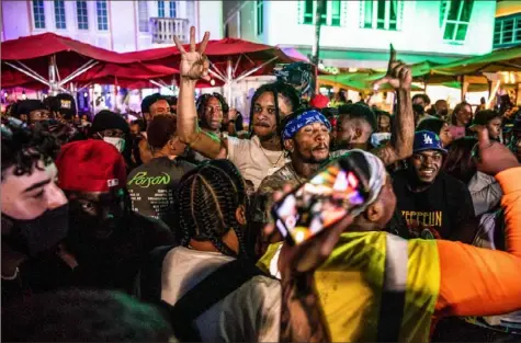  ?? Chandan Khanna/AFP via Getty Images ?? Miami Beach is overrun by crowds of spring-break tourists throwing COVID-19 caution to the wind. The city has extended a state of emergency to stem the chaos. Two North Carolina men have been charged with raping a woman, who later died.