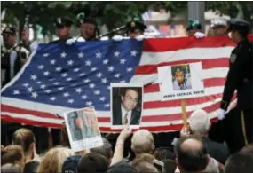  ?? THE ASSOCIATED PRESS ?? Mourners hold photos of their loved ones during the 15th anniversar­y of the attacks of the World Trade Center at the National September 11 Memorial on Sunday in New York.