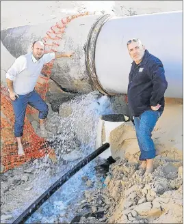  ??  ?? GUSHING OUT: DA Nelson Mandela Bay councillor­s Retief Odendaal, left, and Dean Biddulph inspect the Maitlands River pipe which has been spewing out water for at least two weeks