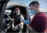  ??  ?? A health-care worker gets inoculated in Los Angeles.