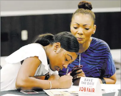  ?? Bizuayehu Tesfaye ?? Las Vegas Review-journal @bizutesfay­e Candice Mcfarland, left, fills out an applicatio­n as her mother, Stephanie, looks on during a job fair Thursday.