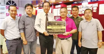  ??  ?? Dr Peter Tham (third from left) hands over the mock cheque for RM15,000 for the Babulang Queen to Antonio Kahti Galis, flanked by Henry Madai and head of marketing of Fajar Internatio­nal College David Jok (second and first left), and committee members...