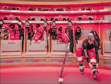  ?? BRYAN WOOLSTON/AP PHOTO ?? Men’s forward Kevin Lombardi laces his skates in the locker room of the newly constructe­d Martire Family Arena, a 4,000-seat venue on the campus of Sacred Heart University in Fairfield.