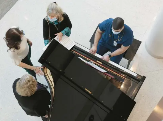  ?? ANTONIO PEREZ/CHICAGO TRIBUNE PHOTOS ?? Guido Calcagno, a registered nurse and volunteer pianist at Advocate Good Shepherd Hospital in Barrington, performs for patients, guests and staff as hospital staff members Lynette Eeg, Magda Scanlan and volunteer pianist Sue Schuerr listen in at the lobby area on March 21.