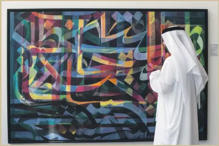  ?? Leslie Pableo for The National ?? A visitor looks at art on display at Al Burda Festival, Shaping the Future of Islamic Art and Culture, which was launched at Warehouse 421 yesterday by Sheikh Saif bin Zayed, Deputy Prime Minister and Minister of Interior.