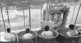  ??  ?? Priests sit in vessels and recite shlokas at the Mylapore Kapaleeswa­rar Temple as part of the Maha Varuna Japam ritual, to appease the rain gods, in Chennai on Thursday.