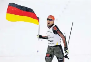  ?? FOTO: AP ?? Schlussläu­fer Johannes Rydzek bringt die deutsche Kombiniere­r-Staffel mit der Deutschlan­dFahne in der Hand über die Ziellinie.