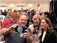  ?? BILL GLAUBER / MILWAUKEE JOURNAL SENTINEL ?? Democratic U.S. Sens. Tammy Baldwin (center) and Kamala Harris (right) pose for a photo with Jim Livesy of Milwaukee at a campaign event Saturday at the Italian Community Center.