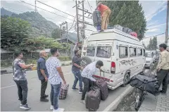  ?? REUTERS ?? Indian tourists load their luggage onto a passenger vehicle on Saturday as they prepare to leave Srinagar, India.