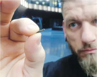  ?? JAMES BROOKS, THE ASSOCIATED PRESS ?? Jowan Osterlund from Biohax Sweden holds a small microchip implant, similar to those implanted into workers at the Epicenter digital innovation business center during a party at the co-working space in central Stockholm. Three Square Market of River...