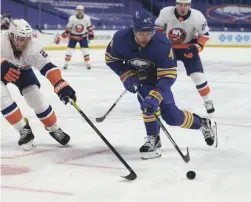  ?? TIMOTHY T. LUDWIG/USA TODAY SPORTS ?? Sabres left wing Taylor Hall (4) skates with the puck as Islanders defenseman Scott Mayfield (24) tries to defend during the second period at KeyBank Center on Tuesday.