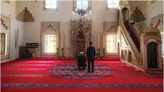  ?? Associated Press ?? Q Two clerics pray Thursday inside the 16th-century Gazi Husrev-beg Mosque in Sarajevo, Bosnia, as worshipers stay away because of the national lockdown the authoritie­s have imposed, attempting to limit the spread of the new coronaviru­s.