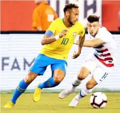  ?? — AFP photo ?? Brazil’s foward Neymar (left) vies for the ball with US midfielder Paul Arriola during their friendly match at the Metlife Stadium in East Rutherford, New Jersey in this Sept 07, 2018 file photo.