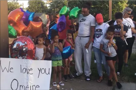  ?? KEVIN MARTIN — THE MORNING JOURNAL ?? Benjamin Rogers participat­es in a vigil for his four-year-old son Omeire West on July 17on 2nd St. in Elyria. Omeire died in a July 7house fire that destroyed a the home.