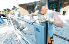  ?? Fotos: Andreas Brücken ?? Mitarbeite­r des Bauhofs installier­ten gestern testweise die mobilen Hochwasser schutzwänd­e. NEU ULM