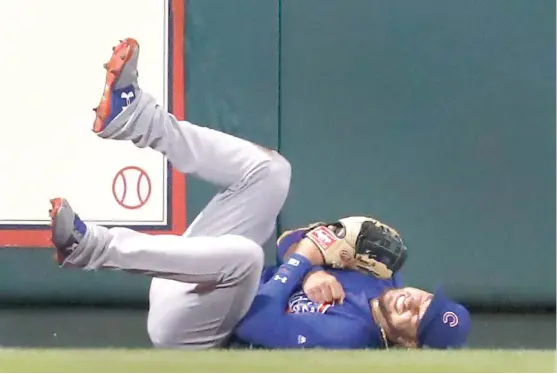  ?? | AP ?? Cubs center fielder Albert Almora Jr. holds his shoulder after slamming into the wall in the fifth inning. X- rays were negative, and he suffered only a bruise.