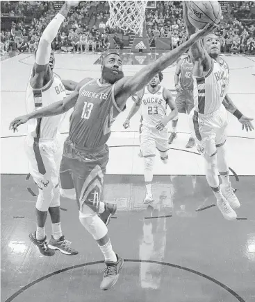  ?? Eric Christian Smith photos / Associated Press ?? Rockets guard James Harden (13) drives between Bucks center Thon Maker, left, and guard Eric Bledsoe on his way to scoring a game-high 31 points on 8-for-21 shooting.