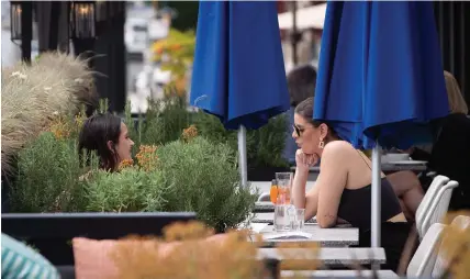  ?? DARRYL DYCK
THE CANADIAN PRESS ?? Two women have drinks on the patio at an Earls restaurant in Vancouver on Tuesday. Dr. Theresa Tam, Canada’s chief public health officer, said “there is no one size fits all” strategy to reopening provinces and territorie­s.