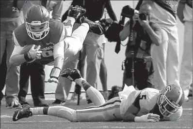  ?? Arkansas Democrat-Gazette/BENJAMIN KRAIN ?? Arkansas quarterbac­k Brandon Allen leaps over Georgia defender Damian Swann during the first quarter of Saturday’s game at War Memorial Stadium in Little Rock. Allen completed 28 of 45 passes for 296 yards and 3 touchdowns in the Razorbacks’ 45-32 loss.