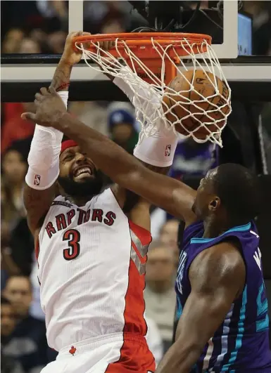  ?? RICK MADONIK/TORONTO STAR ?? James Johnson slams home two points in the first half as Charlotte forward Jason Maxiell tries to stop him on Thursday.
