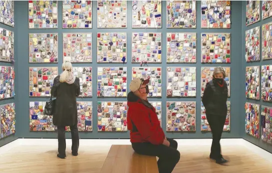  ?? ARKANSAS DEMOCRAT-GAZETTE FILE PHOTOS ?? Demara Titzer of Bella Vista, from left, and Larry Fortner and Lynn Fortner of Bentonvill­e look through the art installmen­t Beaded Prayers Project at the Crystal Bridges Museum of American Art in Bentonvill­e.