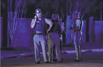  ?? Sean Rayford / Associated Press ?? South Carolina state troopers gather on Hoffmeyer Road near the Vintage Place neighborho­od where several law enforcemen­t officers were shot, one fatally, on Wednesday in Florence, S.C.