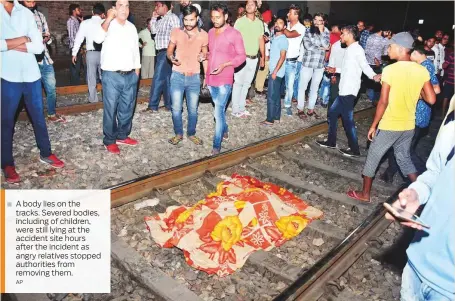  ?? AP ?? A body lies on the tracks. Severed bodies, including of children, were still lying at the accident site hours after the incident as angry relatives stopped authoritie­s from removing them.