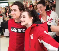  ?? CP PHOTO ?? Olympic gold medallists Scott Moir and Tessa Virtue pose for a photo with a crowd of well-wishers as they arrive home from the Olympics at the airport in London, Ont.