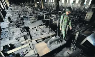  ?? The Associated Press/files ?? A Bangladesh­i police officer walks in a fire-damaged factory outside Dhaka on Nov. 25.