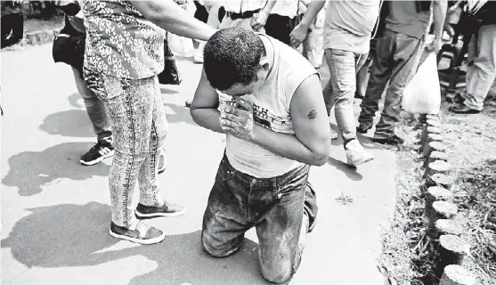  ?? JORGE CABRERA/REUTERS ?? El joven Marvin Toruno, detenido por manifestar­se, reza tras ser liberado ayer en Managua.