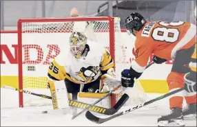  ?? Chris Szagola / Associated Press ?? Philadelph­ia’s Joel Farabee, right, scores a goal on Pittsburgh goaltender Tristan Jarry during the second period of their NHL opener on Wednesday.