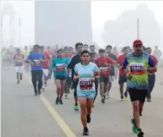  ??  ?? NEW DELHI, India: Participan­ts run past the India Gate monument shrouded by the haze during the Delhi Half Marathon in New Delhi yesterday. — AP