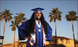  ?? The Associated Press ?? LAVEEN, ARIZ.: Harvard bound Abia Khan, the valedictor­ian of her Class of 2020 at North High School, stands in her cap and gown in Laveen, Ariz., on May 5. Abia addressed her class in a virtual graduation speech. “One thing I’ve realized is the importance of connection — not only in times of isolation but also in times we are together,” she said in the speech for which she also wore her cap and gown while recording in front of her computer. “… I hope that as we move forward in our lives, we keep striving to make those connection­s.” Abia is the daughter of immigrants from Bangladesh. She says her parents taught her the importance of a college education, especially when her father was laid off in the Great Recession. When asked for her dream for herself, it was pretty simple: “Stability.”
