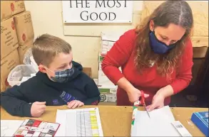  ?? Mark Thiessen / Associated Press ?? DeeDee Hinkley, wife of Chief Master Sgt. Winfield Hinkley Jr., command senior enlisted leader of the Alaska National Guard, and their son Noah wrap a gift in Anchorage, that will be sent to a child in one of three rural Alaska villages.