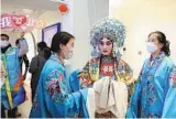  ?? PHOTOS BY WU XIAOHUI / CHINA DAILY ?? Clockwise from top: Members of a media tour pose for a photo at the Temple of Heaven, part of Beijing’s historic central axis, on Feb 1. A Peking Opera performer talks with guests of a media tour at an intangible cultural heritage center in Beijing on Feb 14. Journalist­s try out digital renminbi payment at the New Actuation Fintech Center in Beijing on Feb 17.