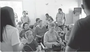  ??  ?? Residents of Jayuya listen to aid workers who came from nearby Ponce, Puerto Rico, to offer help and informatio­n.