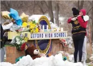  ?? AP PHOTO/PAUL SANCYA ?? Students hug at a memorial at Oxford High School in Oxford, Mich., on Wednesday. Authoritie­s say a 15-year-old sophomore opened fire at Oxford High School, killing four students and wounding seven other people on Tuesday.