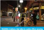  ?? — AFP ?? READING: A delivery rider talks to a police officer securing a police cordon in central Reading on Saturday following a stabbing incident at Forbury Gardens park.