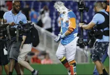  ??  ?? Miami Marlins’ Miguel Rojas walks off the field covered in shaving cream after he was mobbed by teammates following his sacrifice fly that scored Derek Dietrich during the 11th inning of a baseball game against the San Diego Padres, Saturday, in Miami....