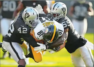  ?? BEN MARGOT/AP PHOTO ?? Pittsburgh Steelers tight end Jesse James (81) is tackled by Oakland Raiders safety Karl Joseph (42) and linebacker Tahir Whitehead (59) during the first half of Sunday’s game at Oakland, Calif.