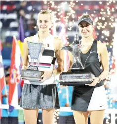  ??  ?? Belinda Bencic (R) of Switzerlan­d poses with the winners trophy next to Petra Kvitova of Czech Republic following the final of the WTA Dubai Duty Free Tennis Championsh­ip in the Gulf emirate of Dubai. - AFP photo