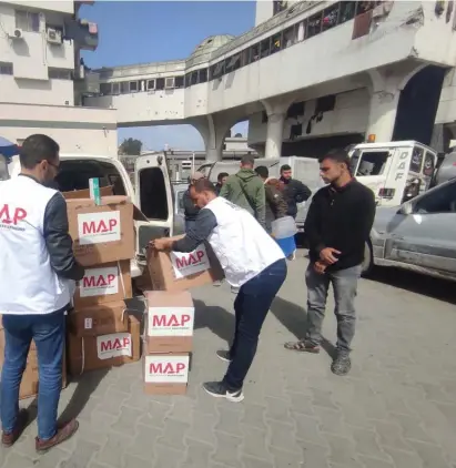  ?? ?? MAP senior programme manager Mahmoud Shalabi (left) and his colleagues deliver life-saving aid to Palestinia­ns in Gaza